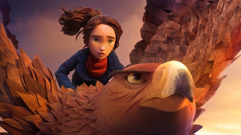 Animated young rider with tousled hair sits behind a large feathered bird, silhouetted by a warm sunset sky.
