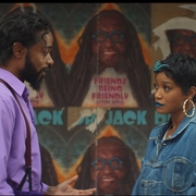 A man and a woman looking at each other standing in front of a wall of posters.